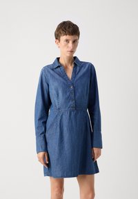 Denim obleka s ovratnikom, sprednjim gumbom in dolgimi rokavi. Ima oprijet pas in razširjeno krilo v srednji modri barvi. Gladka tekstura.