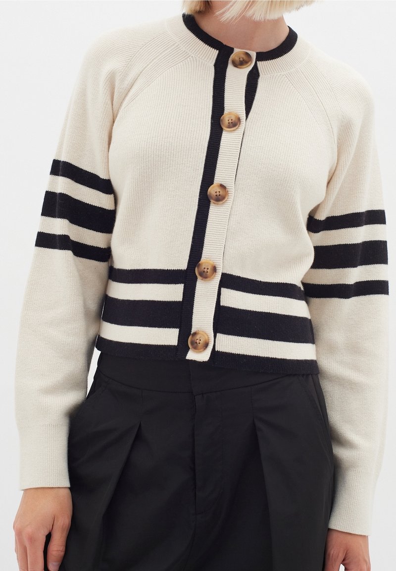 Beige stickad kardigan med svarta ränder, med rund nacke och fem stora träknappar framtill. Kort passform och ribbad textur.