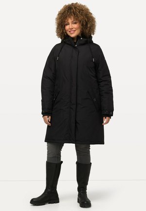 Black insulated coat with a hood, zippered front, and side pockets. Worn over gray pants and knee-high black boots. Textured fabric.