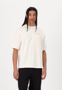 Hvid kortærmet tshirt med smalle orange striber, med rund halsudskæring og lille broderet logo på brystet.