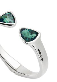 Anillo de plata con dos cristales turquesa talla esmeralda, con un diseño abierto elegante y la marca "UNO de 50" grabada en la banda.