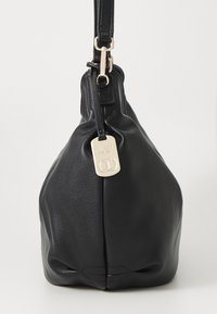 Sac à main en cuir noir avec une forme arrondie, surface texturée et une bandoulière amovible. Dispose d'une étiquette de marque en argent fixée à la fermeture éclair.