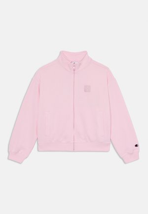 Veste zippée rose avec un col montant, fabriquée en matériau doux, dotée de poches latérales et d'un patch logo sur la poitrine et la manche.