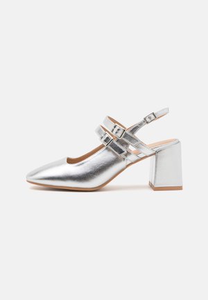 Silver metallic slingback shoe with a pointed toe, wide block heel, and two buckle accents on the ankle strap. Smooth texture.