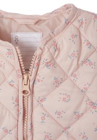 Quilted pink fabric jacket featuring small floral patterns in blue and pink, with a front zipper and tag sewn inside the collar.