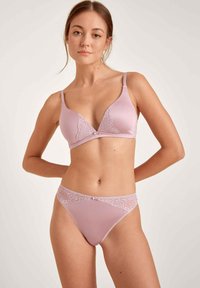 Ensemble en dentelle lavande comprenant un soutien-gorge et un string, avec un design à coque triangulaire, des détails en dentelle et des accents assortis. Tissu doux avec bretelles ajustables.