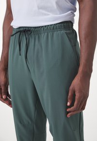 Nike Performance UNLIMITED PANT - Treningo apatinė dalis - vintage green/black