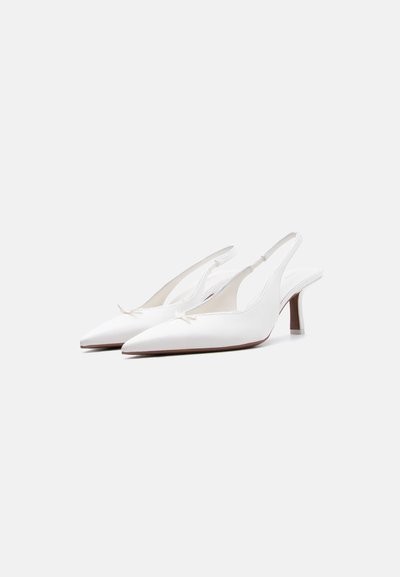 Escarpins blancs à bout pointu avec brides arrière, bas talons stilettos et petits nœuds décoratifs à l'avant.