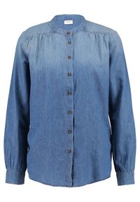 Chemise en denim à boutons, manches longues, col mandarin et boutons marron. Présente un léger dégradé de nuances de bleu et un détail plissé aux épaules.