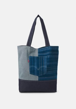 Sac cabas avec un design patchwork en denim dans des tons gris et bleus, doté d'une poche avant avec des détails cousus et de deux anses pour l'épaule.