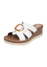 White wedge sandals with a wide, open design and a brown footbed. Features a transparent circular accent and stitched detail on the sole.