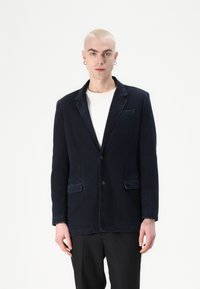 Tumesinine kasurebro blazers, millel on kaks eesmist taskut, ühe nupuga kinnitamine ja nurkidega krae. Tekstuurustatud kangas ja klassikaline lõige.