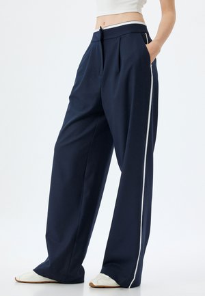 Marinefarbene weite Hosen mit flachem vorne, seitlichen Taschen und weißen Seitenstreifen. Aus glattem Stoff mit taillierter Passform und gefaltetem Design.