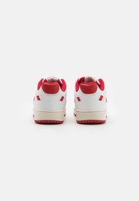 Sneakers bianchi in pelle con accenti rossi e colletto posteriore texture. Presentano una suola intermedia beige e una suola in gomma con battistrada a motivo.