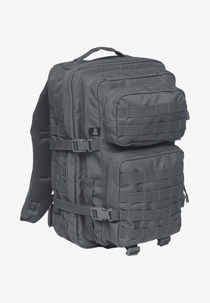 Zaino tattico grigio con molteplici scomparti con zip, webbing per attacchi, schienale in rete imbottita e spallacci regolabili.