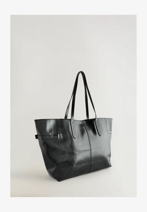 Musta nahkainen laukku, jossa on sileä pinta, kaksi pitkää kahvaa ja minimalistinen muotoilu. Huomiota herättävät saumat ja jämäkkä muoto.