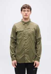 Μακρυμάνικο πουκάμισο ελιάς με κουμπιά μπροστά, δύο τσέπες στο στήθος και κανονικό γιακά. Κατασκευασμένο από ελαφρύ, λείο ύφασμα.