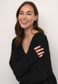 Maglione nero in tessuto lavorato a maglia con collo a V profondo e maniche lunghe e larghe. Materiale morbido e accogliente per un fit rilassato.