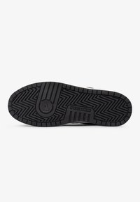 Black rubber shoe sole with textured zigzag pattern and embossed "PEGADOR" logo, featuring a rounded shape and sturdy construction.