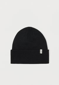 Μαύρο πλεκτό σκουφάκι με διπλωμένο ρέλι, φτιαγμένο από μαλακό ύφασμα. Διαθέτει μια μικρή λευκή ετικέτα στο πλάι. Λείος υφή, στρογγυλή κορυφή.