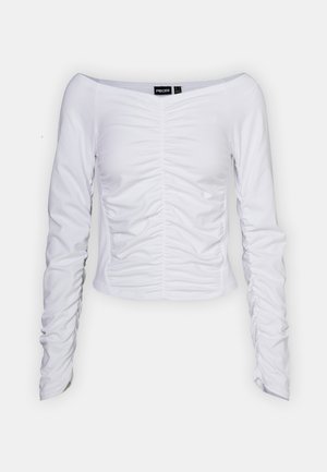 Top bianco a maniche lunghe con design a spalle scoperte, caratterizzato da una texture arricciata nella parte anteriore e una silhouette aderente.