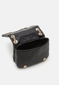 Sac en cuir noir au toucher lisse, doté d'une fermeture à rabat et d'accents en métal doré. L'intérieur comporte un seul compartiment.