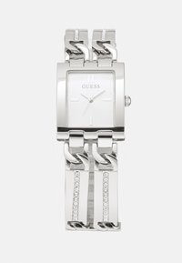 Silver metal watch with a square face, link bracelet, and crystal accents on the band. The dial features minimalist hour markers.