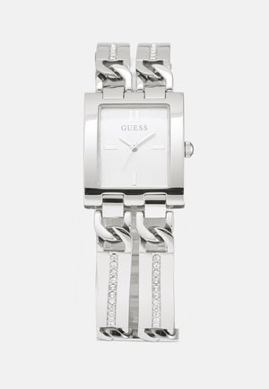 Montre en métal argenté avec un cadran carré, bracelet en maillons et accents en crystal sur le bracelet. Le cadran présente des marqueurs d'heure minimalistes.