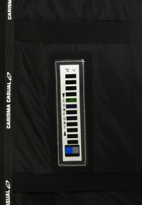 Crni tkaninski panel s pravokutnom kontrolnom pločom koja ima pokazivač temperature. Uključuje indikatore za Celzijus i Farenheit.