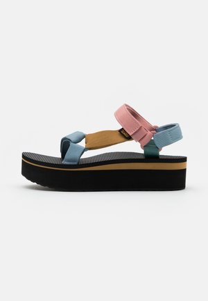 Platformsandal med sort sål, tan accentstribe og justerbare remme i blå, pink og tan farver på en hvid baggrund.
