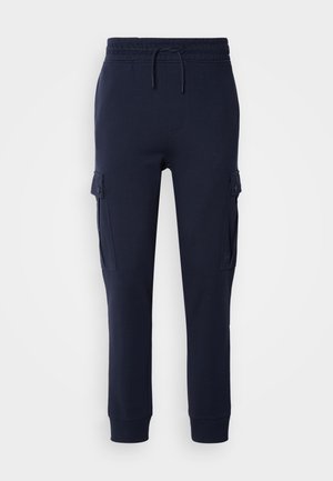 Pantalones de chándal cargo azul marino fabricados con tela suave, con cintura elástica, cordón ajustable y bolsillos laterales con cierres de solapa.