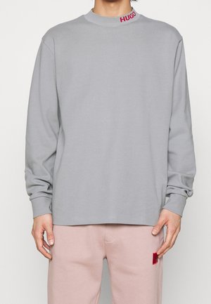 Graues Langarm-T-Shirt mit Rundhalsausschnitt und rotem "HUGO"-Logo am Kragen. Aus weichem Stoff gefertigt, bietet es eine lässige Passform.