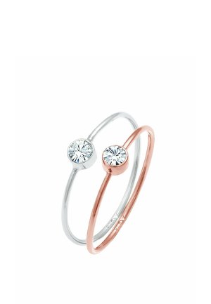 To ringe: en sølv med en rund klar sten, en rosaguld med en tilsvarende sten. Enkle, glatte metalbånd, minimalistisk design.