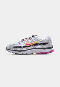 White and gray Nike running shoe with pink and yellow swoosh, black detailing, mesh panels, and pink accents on the sole.