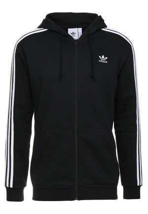Czarna bluza Adidas zapinana na zamek z białymi trzema paskami na rękawach, kieszeniami z przodu, regulowanym kapturem z troczkami oraz małym białym logo Adidas na lewej piersi.