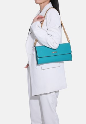 Borsa a tracolla in pelle verniciata turchese con una catena dorata, design rettangolare, texture elegante e un accento discreto del logo sulla parte anteriore.