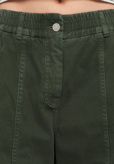 Ελιά προιόντος χρώματος βαμβακερό παντελόνι με ελαστική μέση, ορατό ράψιμο, μεταλλικό κουμπί και πλαϊνές τσέπες για πρακτικότητα.
