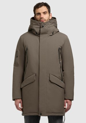 Heren lange, capuchon parka van matbruin stof. Voorzien van grote zijzakken, een ritszak opzij en een verstelbare trekkoord onderkant.