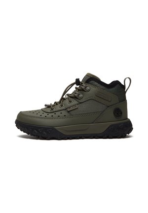 Olijfgroene mid-top wandelschoen met zwarte gestructureerde zool, trekkoord en elastisch vetersysteem, met Timberland-logo op de hiel en zijkant.