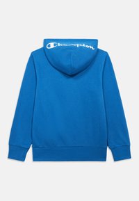 Μπλε φούτερ με απαλό ύφασμα, με κουκούλα και ριμπ μανσέτες. Λευκό λογότυπο "Champion" στην πλάτη, μίνιμαλ σχεδιασμός.