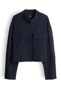 Giacca corta blu navy con collo alla coreana, maniche lunghe, quattro bottoni frontali e due ampie tasche a patta sul petto.