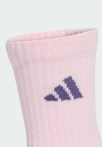 Calcetín rosa claro hecho de material suave, con textura acanalada y un logo de adidas morado bordado en el costado.
