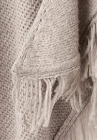 Light gray woven fabric with a textured pattern and frayed edges, showcasing a soft, chunky knit and subtle sheen in the material.