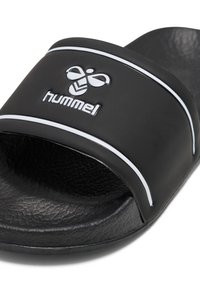Svart slidesandal med en texturerad sula och ett brett band som har en vit accentlinje och en logo. Tillverkad av syntetiskt material.