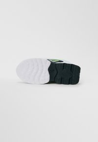 Sporta apavu zole ar melnbaltu zīmējumu, kas nodrošina teksturētu saķeri, un neliels melns swoosh logo tuvu vidum.