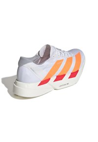 Zapatilla deportiva blanca con acentos de rayas naranjas y rojas, fabricada en un material ligero, con un talón texturizado y un logotipo visible en la suela.