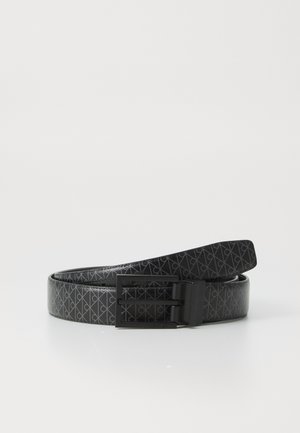 Svart lærbelte med geometrisk mønster og spenne i svart metall. Glatt tekstur med blank overflate. Har Calvin Klein-vermerk på spennen.