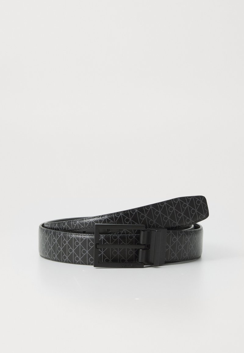 Svart lærbelte med geometrisk mønster og spenne i svart metall. Glatt tekstur med blank overflate. Har Calvin Klein-vermerk på spennen.