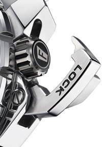 Sidabrinis metalinis užrakto mechanizmas su tekstūruotais akcentais ir logotipo detale. Siūlo blizgantį paviršių ir išskirtinį kampuotą dizainą.