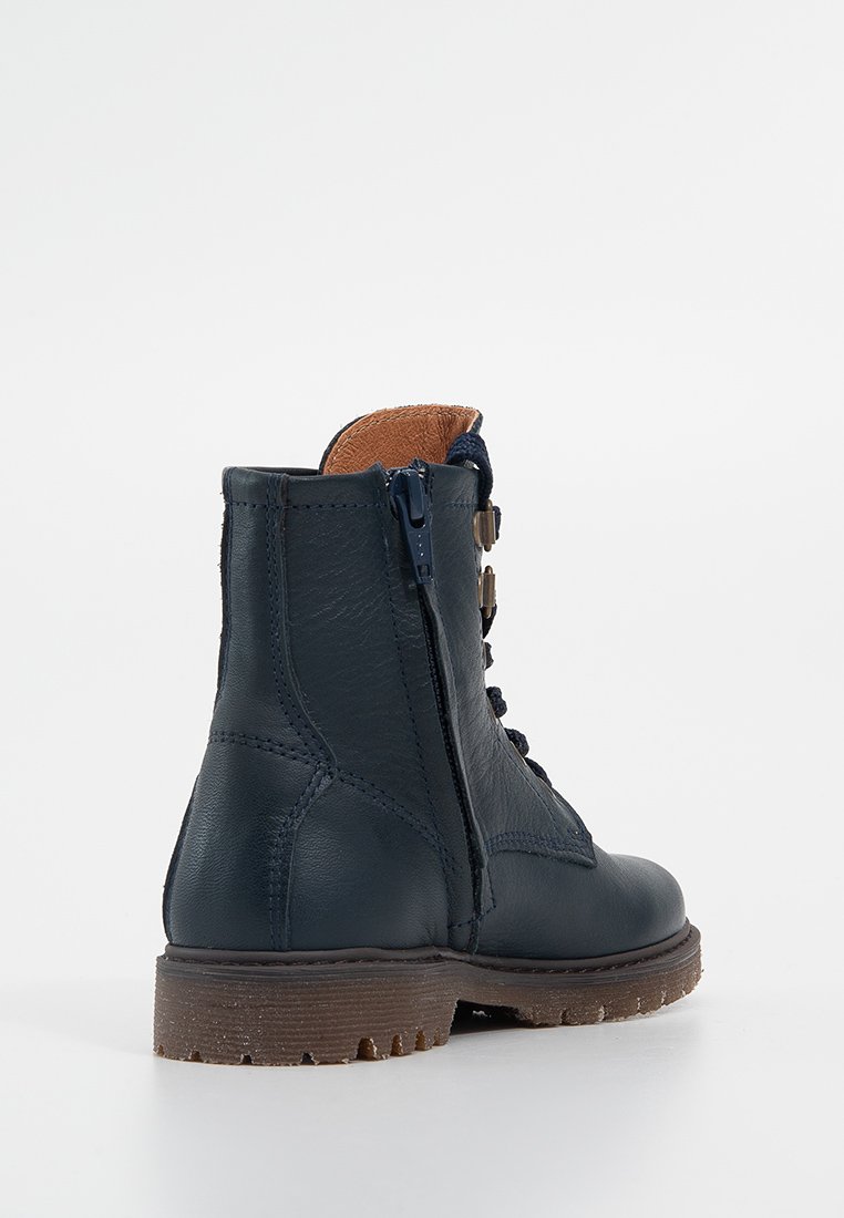 Navyblaue Leder-Ankle-Boots mit strukturiertem Finish, seitlichem Reißverschluss und kontrastierender brauner Kunstfell-Fütterung, ausgestattet mit einer robusten Sohle.